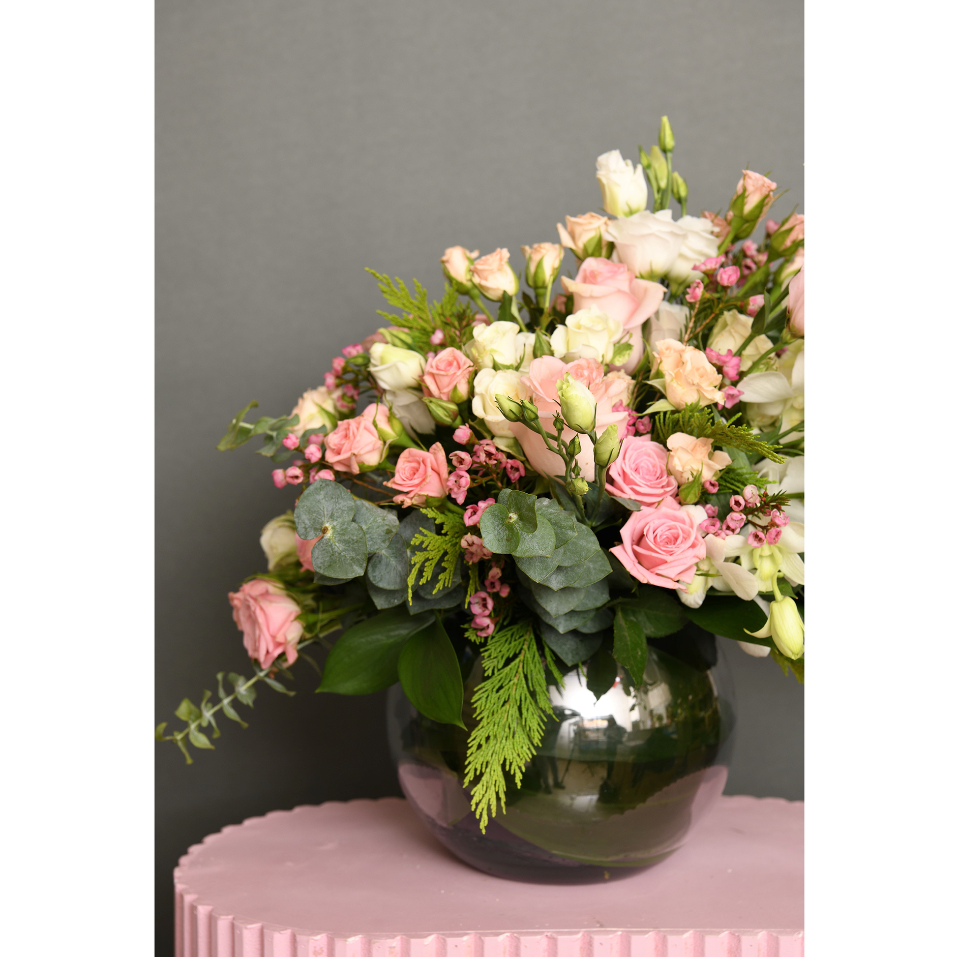Vase of roses, baby rose, wax flower, astomaea, and orchid